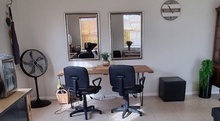 Chic styling area at Sam Swartz Hair & Makeup, Cape Town, Western Cape, ZA with mirrors and chairs.