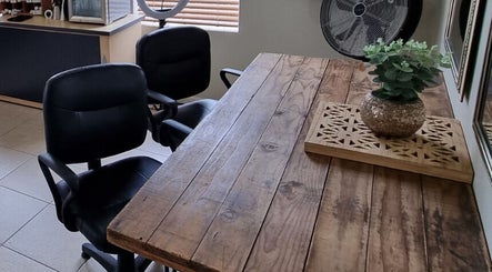 Rustic wooden table and chairs at Sam Swartz Hair in Cape Town, Western Cape, ZA, with chic decor.