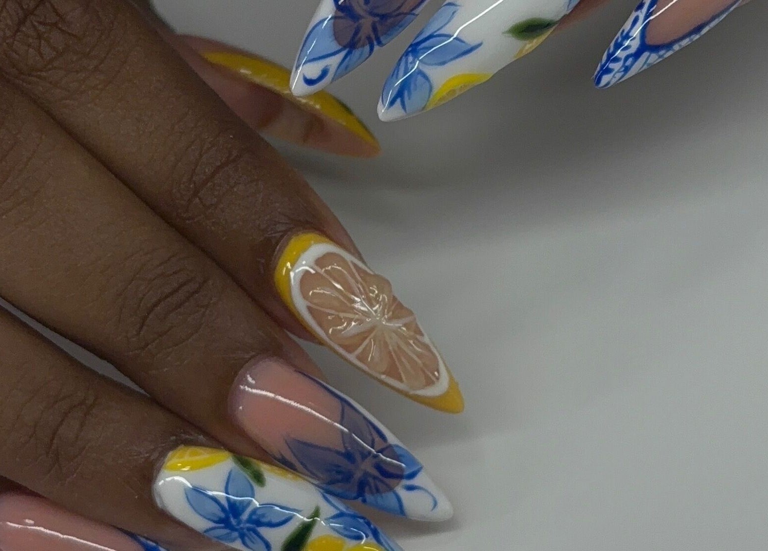 Devine Essence creates floral and citrus nail art in Willemstad, CW, showcasing vibrant, detailed designs.
