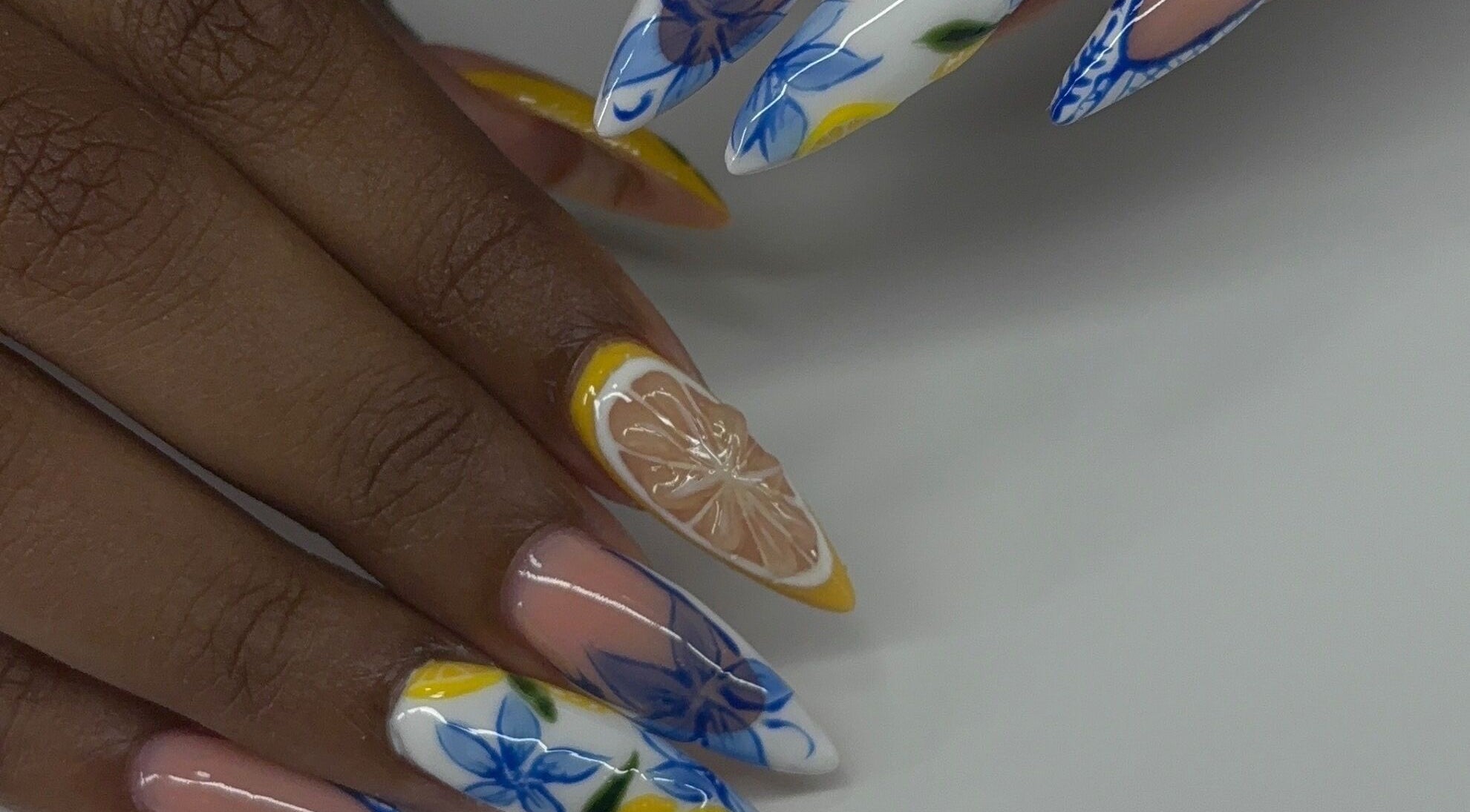 Devine Essence creates floral and citrus nail art in Willemstad, CW, showcasing vibrant, detailed designs.