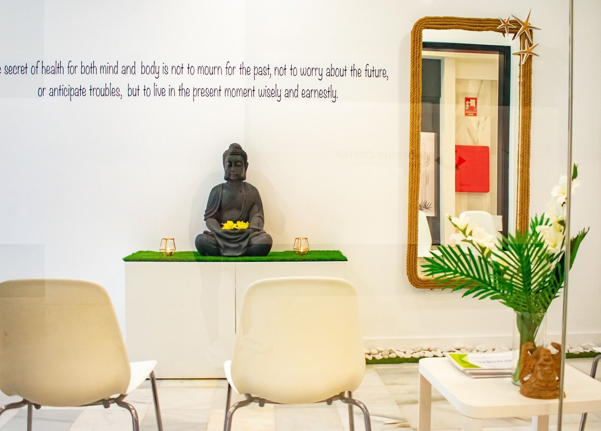 Área de espera tranquila en Hit Global Therapy | Massage & Wellness Tenerife, Arona, ES, con figura de Buda.