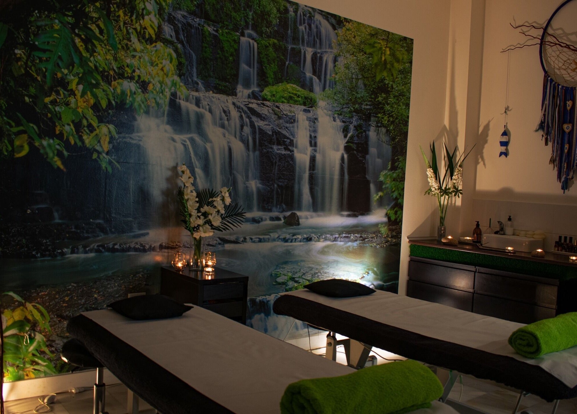 Ambiente relajante en Hit Global Therapy | Massage & Wellness Tenerife, Arona, ES, con camas de masaje junto a una cascada