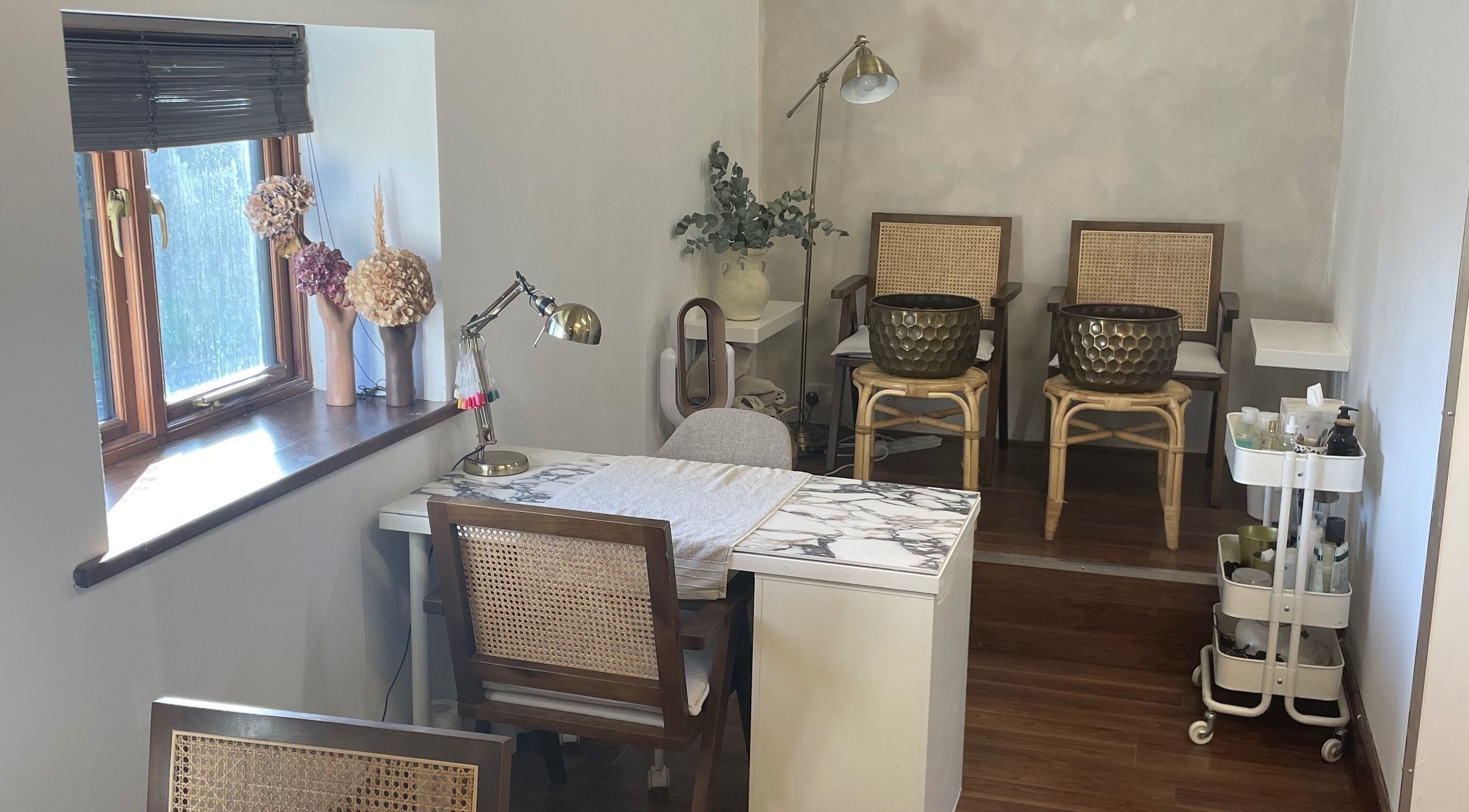 Chic nail salon at The Beauty Barn, Seckington, England, GB, adorned with natural tones and rattan furniture.