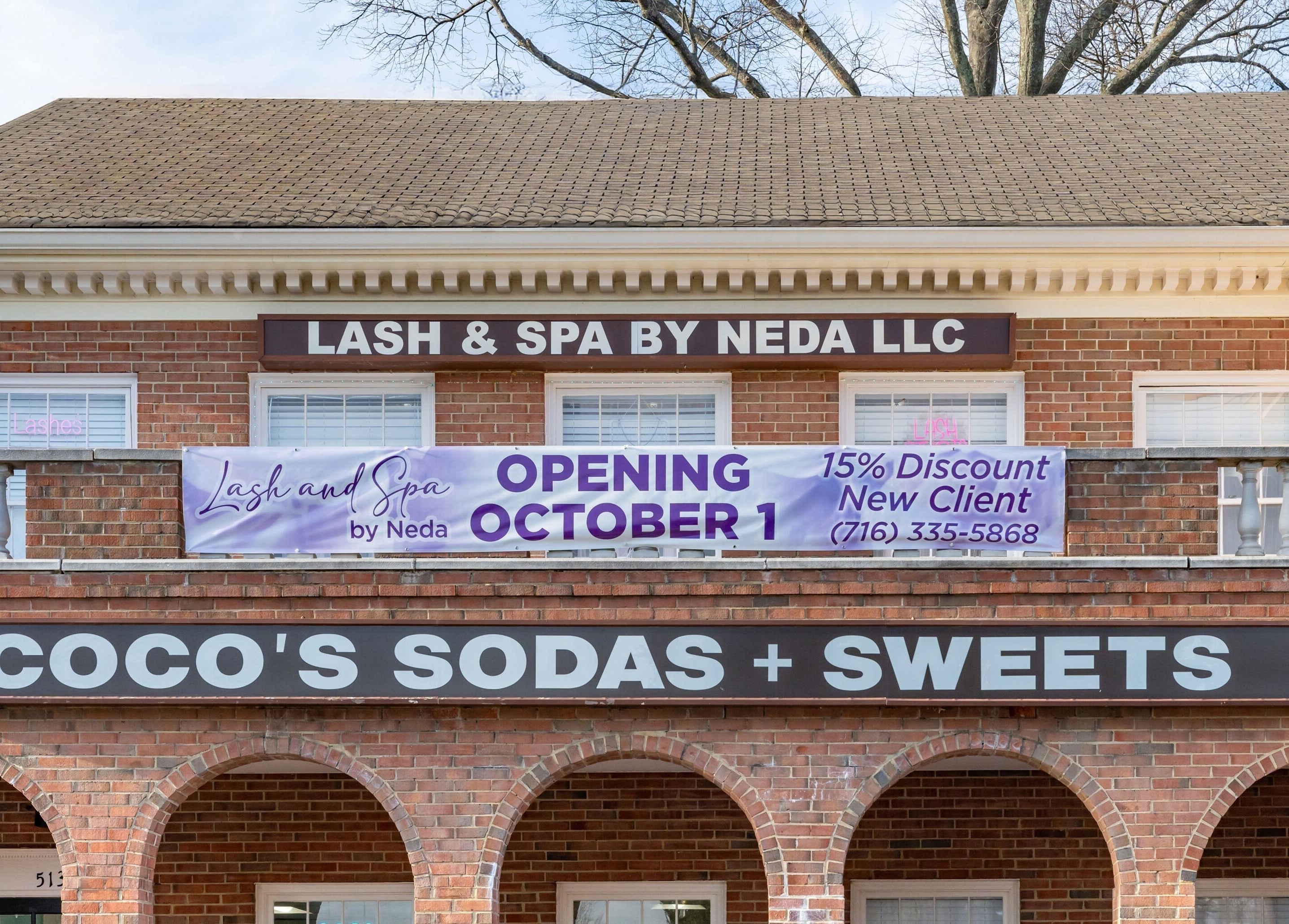 Exterior of Lash and Spa ByNeda in Vienna, VA, US, showcasing a classic brick facade with a prominent sign.