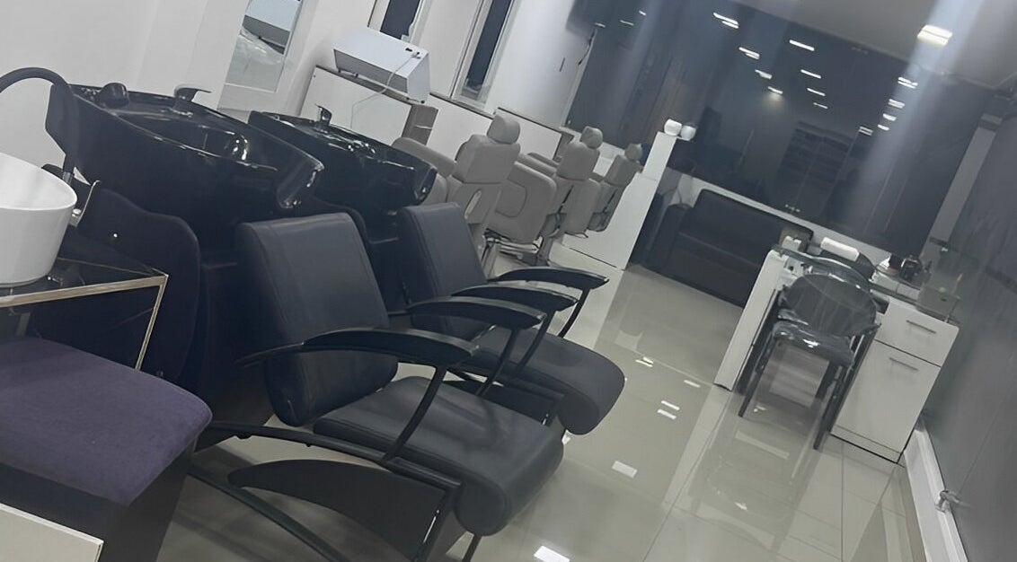 Interior moderno de Beauty Moments en Quito, Pichincha, EC con estación de lavado y sillas elegantes.