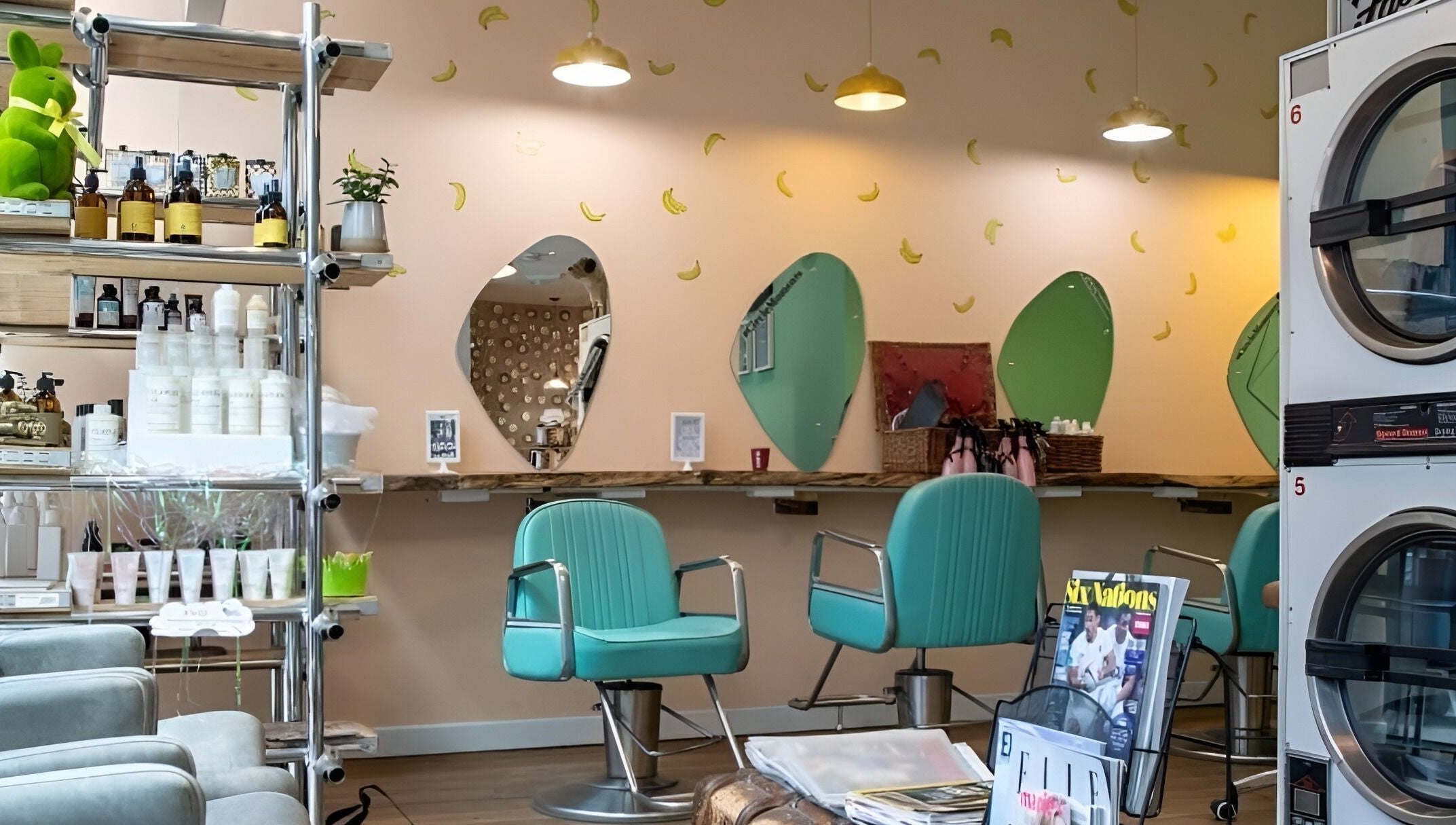 Interior of The Curious Comb in London, England, GB with teal chairs and banana-decorated walls.