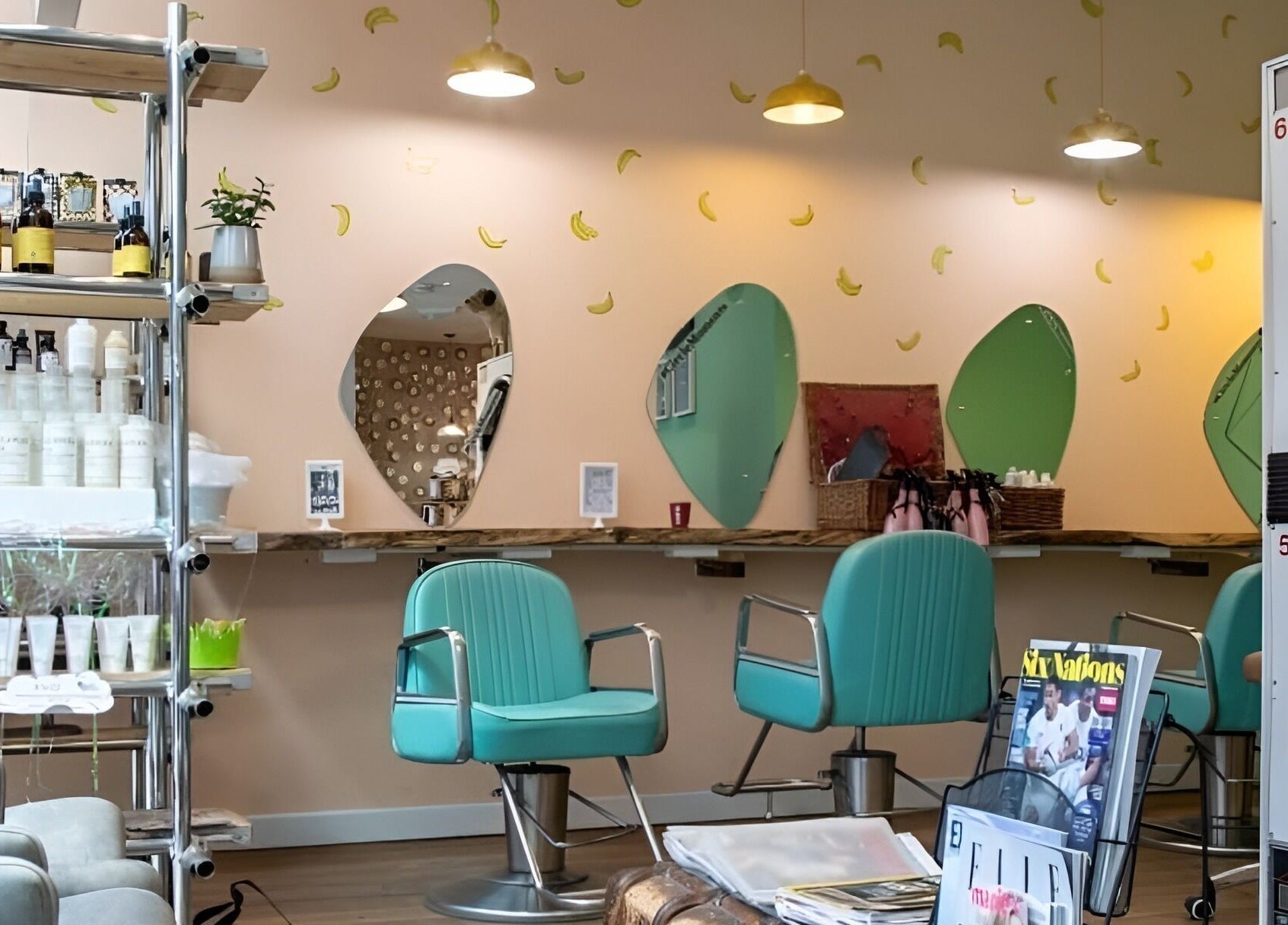 Interior of The Curious Comb in London, England, GB with teal chairs and banana-decorated walls.