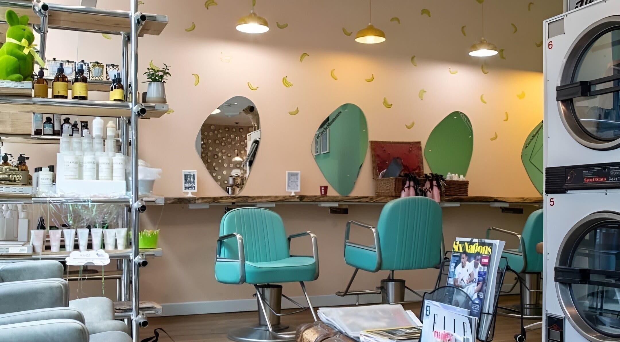 Interior of The Curious Comb in London, England, GB with teal chairs and banana-decorated walls.