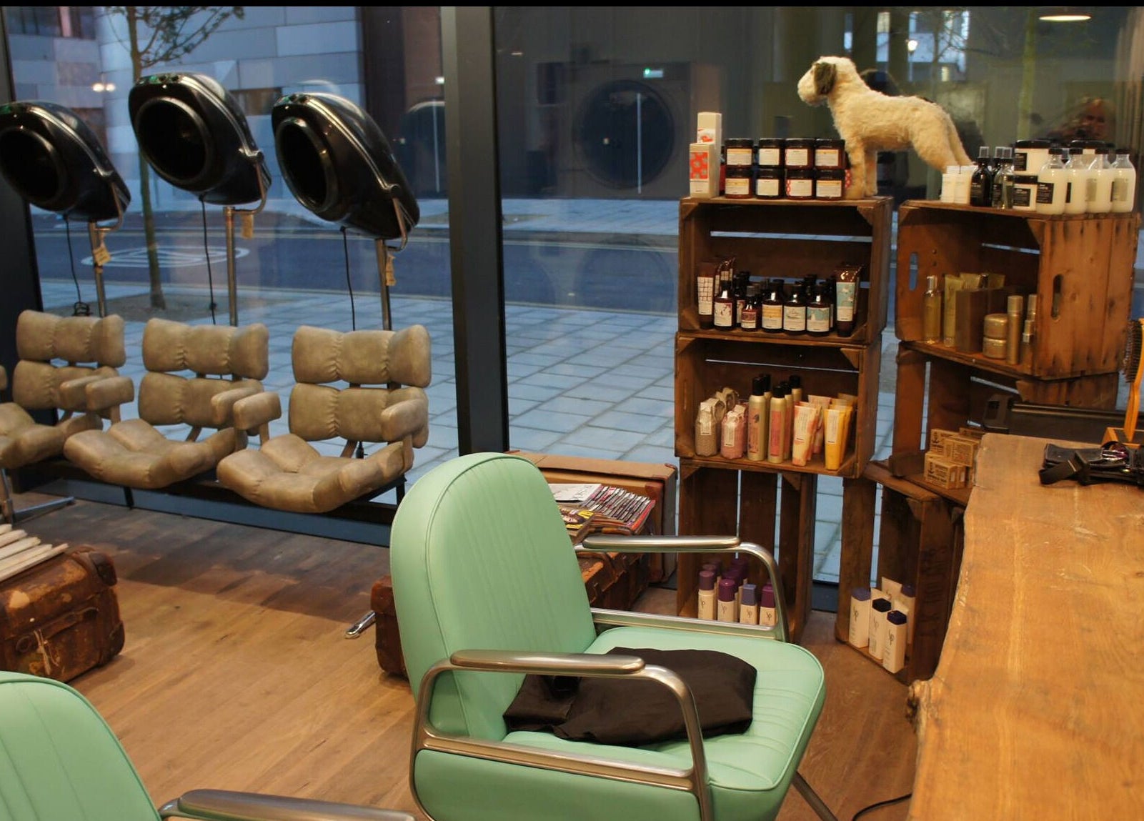 Cozy interior of The Curious Comb, London, England, GB with styling chairs and shelves of beauty products.