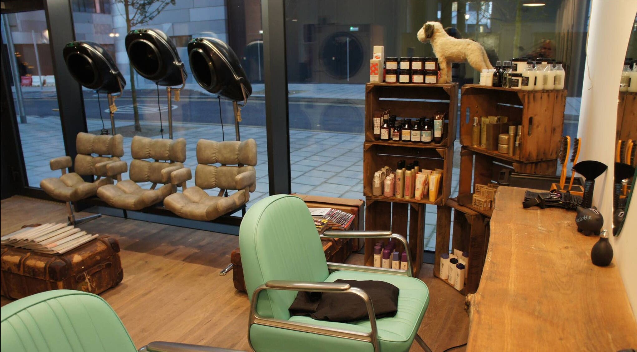 Cozy interior of The Curious Comb, London, England, GB with styling chairs and shelves of beauty products.