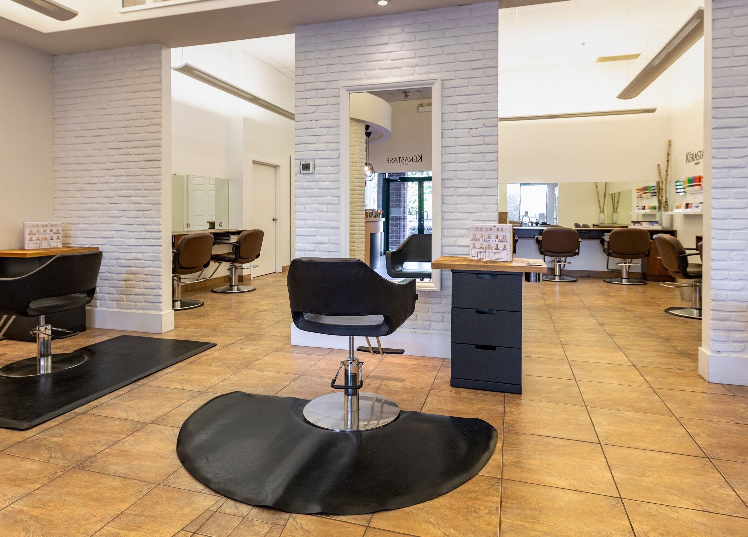 Intérieur moderne de Concept Fuzion Coiffure à Beloeil, Québec, CA, avec chaises et miroirs élégants.