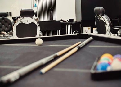 Billiard table with cue sticks at Royal Shave Barber, Dubai, AE, creating a unique grooming ambiance.