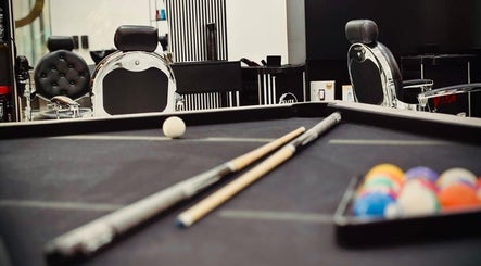Billiard table with cue sticks at Royal Shave Barber, Dubai, AE, creating a unique grooming ambiance.