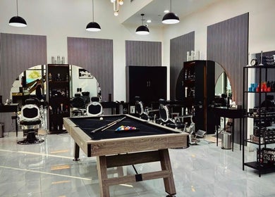 Stylish interior of Royal Shave Barber in Dubai, AE with chic barber chairs and a billiard table.