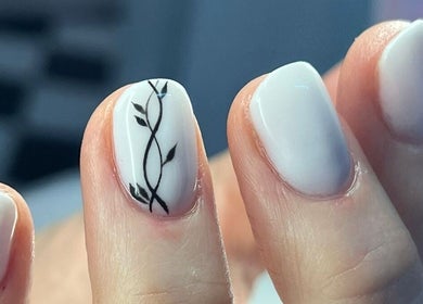 Close-up of chic nail art at Salon@735, Pretoria, Gauteng, ZA, featuring white polish and delicate black design.