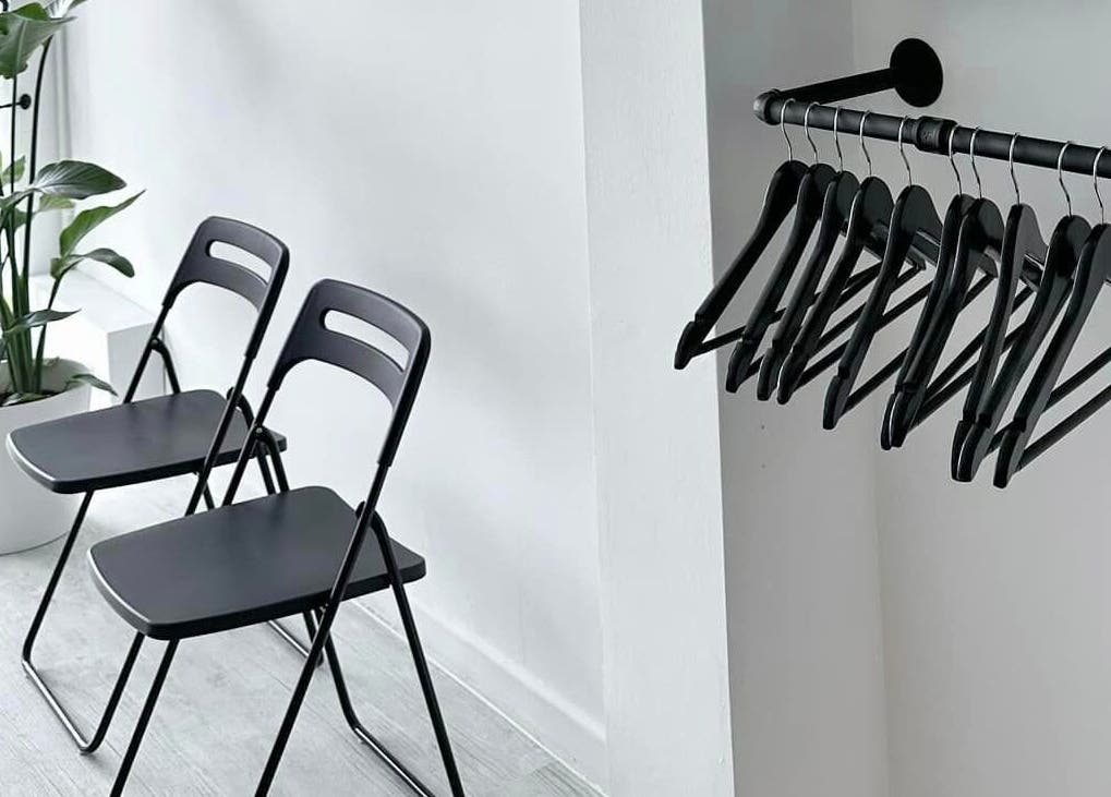 Chic waiting area at Solomengroomingsalon, Beeston, England with black chairs and a potted plant.