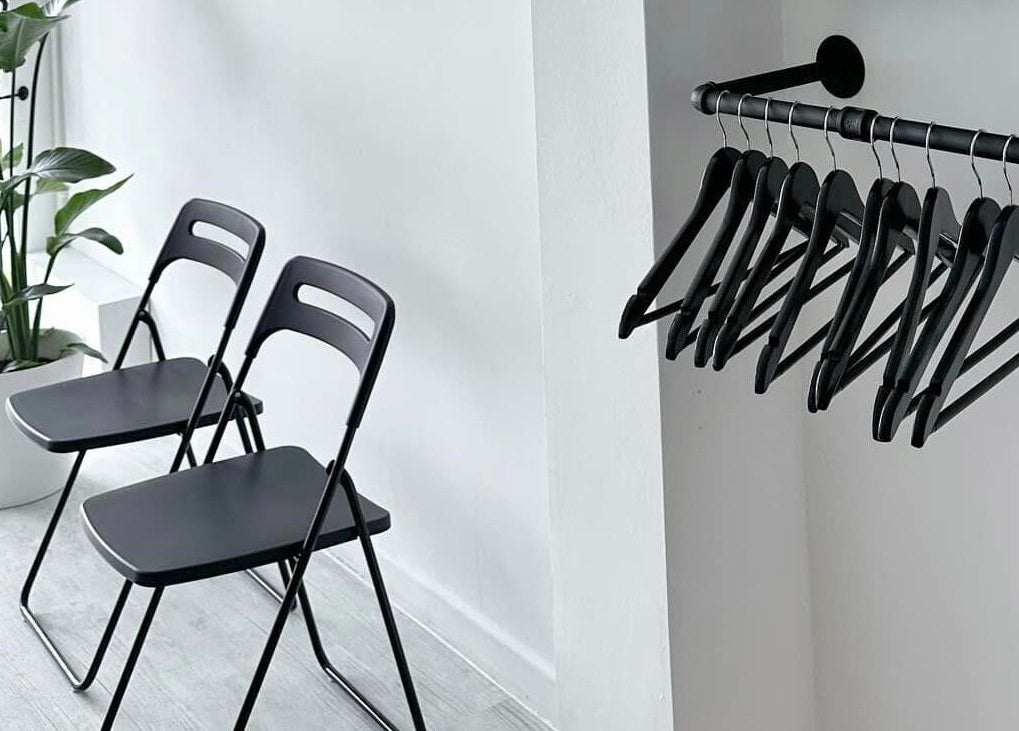 Chic waiting area at Solomengroomingsalon, Beeston, England with black chairs and a potted plant.