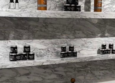 عرض منتجات العناية على رفوف رخامية في Ogi Barber Shop، الرياض، منطقة الرياض، السعودية.