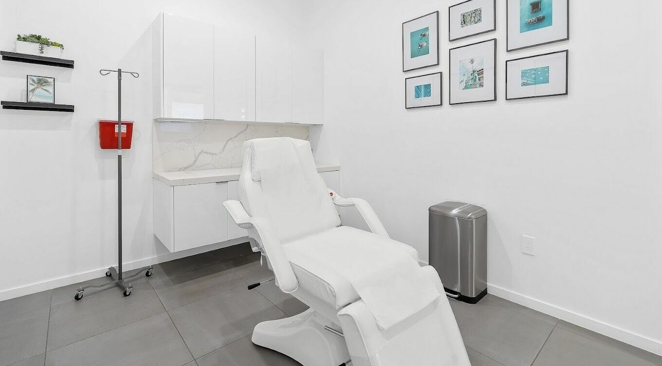 Rejuve Clinics treatment room in Los Angeles, California, US. Sleek white decor with modern medical chair.