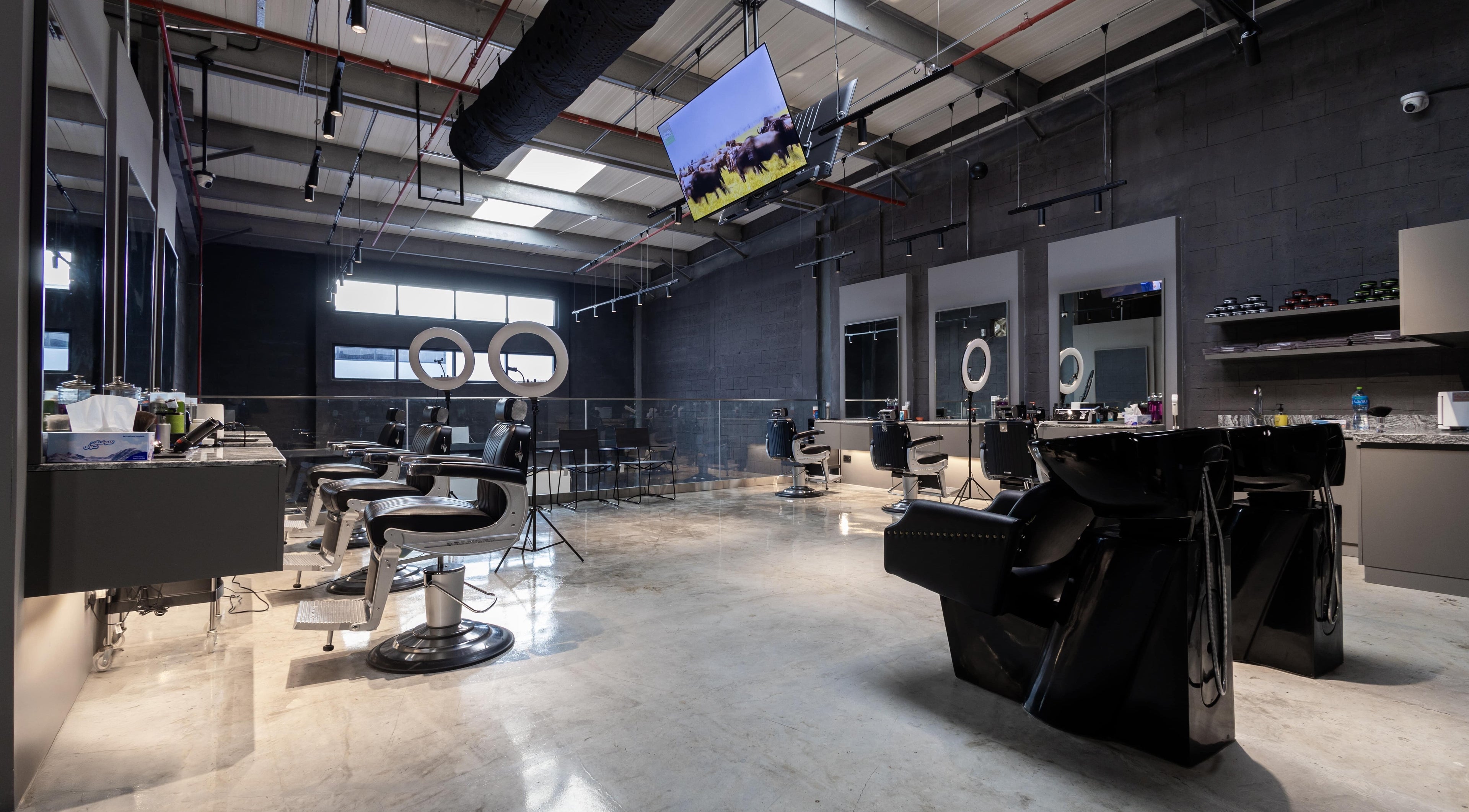 Modern interior of Lvls Barbershop in Dubai, Dubai, AE showcasing barber chairs and sleek design.