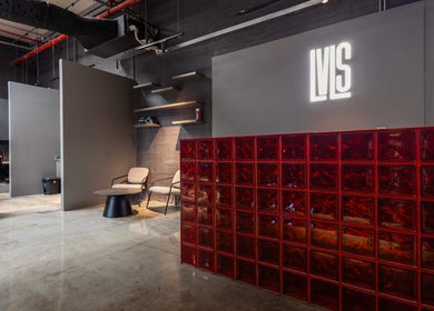Modern interior of Lvls Barbershop, Dubai, AE, featuring sleek decor and red glass panel.