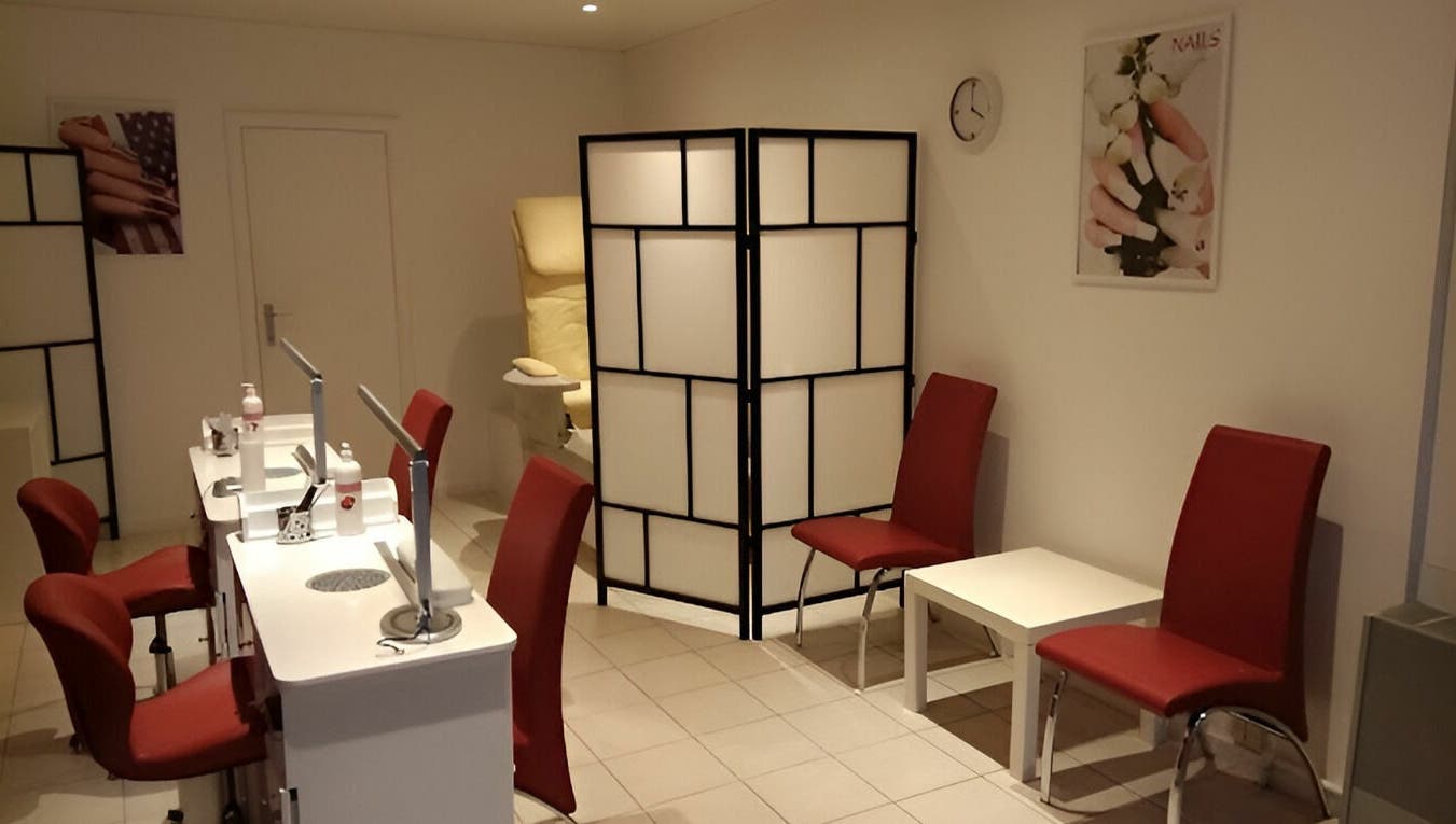Salon lumineux de Phuong Esthetic and Nails Overijse à Overijse, Vlaanderen, BE avec chaises rouges.