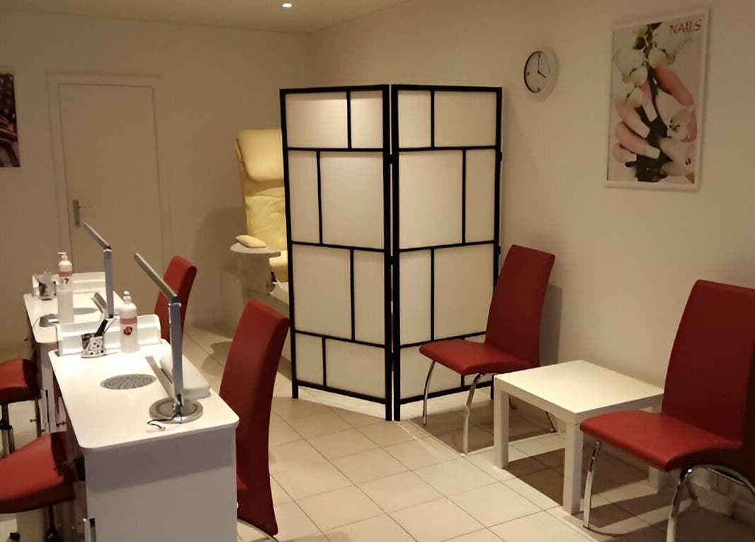 Salon lumineux de Phuong Esthetic and Nails Overijse à Overijse, Vlaanderen, BE avec chaises rouges.