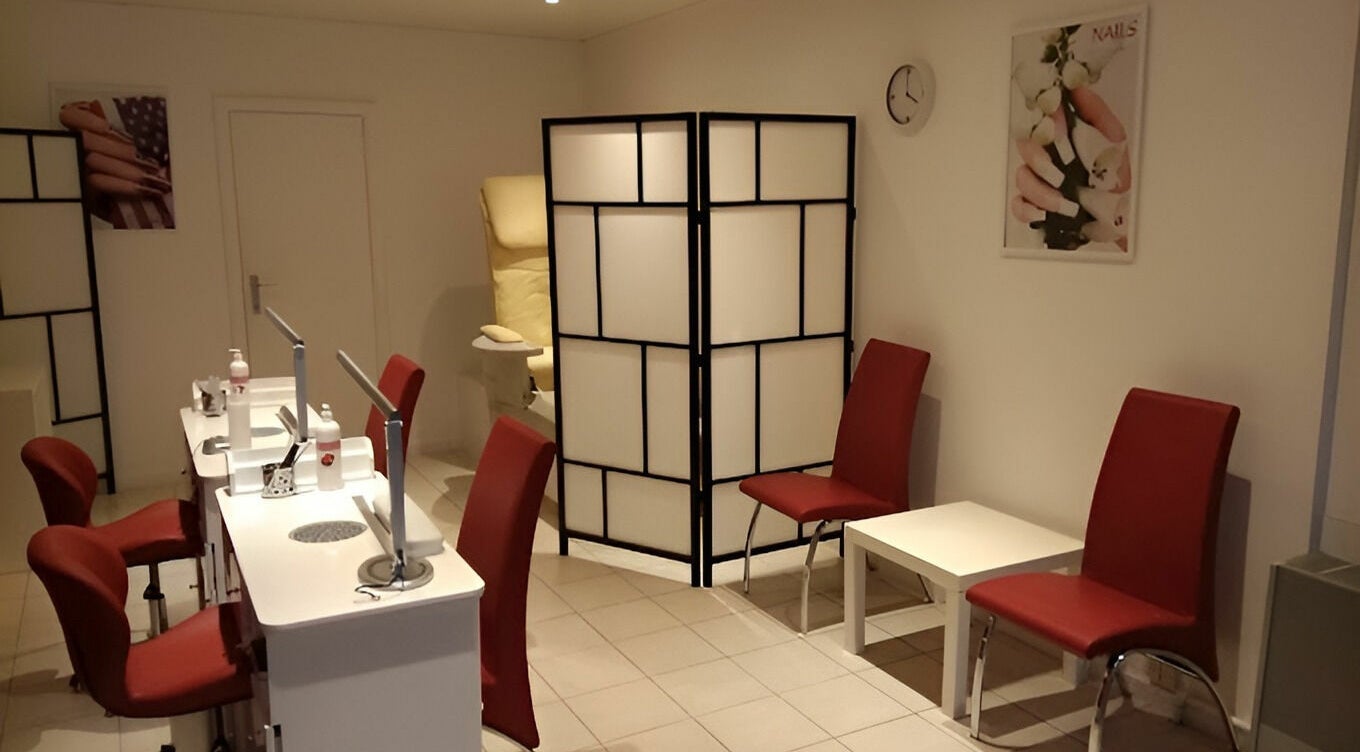 Salon lumineux de Phuong Esthetic and Nails Overijse à Overijse, Vlaanderen, BE avec chaises rouges.