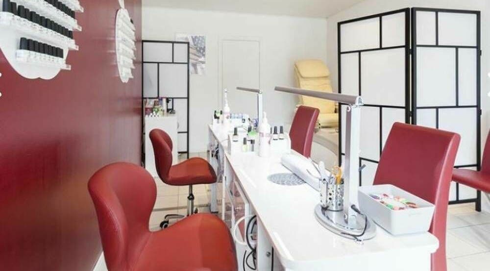 Intérieur élégant de Phuong Esthetic and Nails Overijse, Overijse, Vlaanderen, BE avec chaises rouges et stations de nail art.