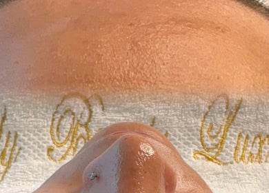 Soin du visage chez Candy Beauty Lux, Luxembourg, LU, avec serviette du logo visible.