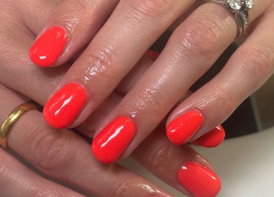 Bright orange manicure at Mani, Birmingham, England, GB showcasing elegant nail art.