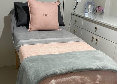 Cozy treatment bed at D'ntle Beauty Randburg, located in Randburg, Gauteng, ZA, showcasing plush pillows and blankets.