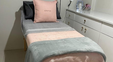 Cozy treatment bed at D'ntle Beauty Randburg, located in Randburg, Gauteng, ZA, showcasing plush pillows and blankets.