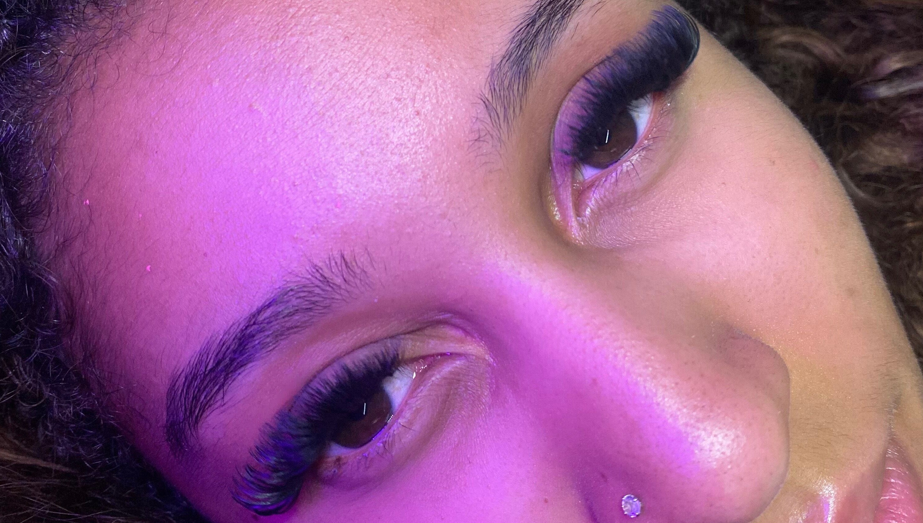 Close-up of luxurious eyelashes at Blinked Boutique, London, England, GB, under soft purple lighting.