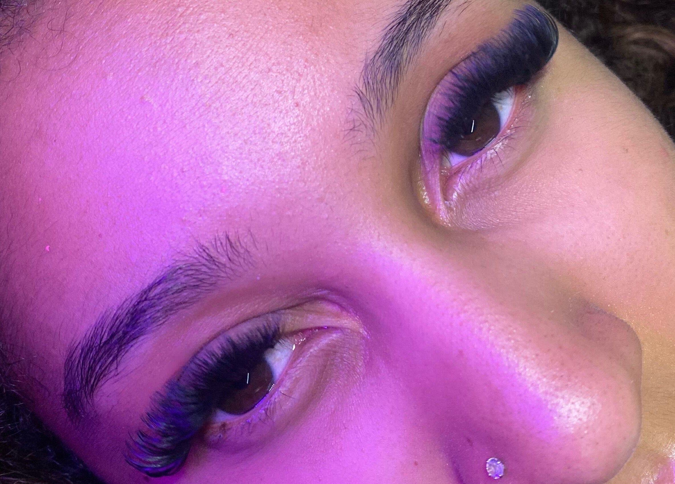 Close-up of luxurious eyelashes at Blinked Boutique, London, England, GB, under soft purple lighting.