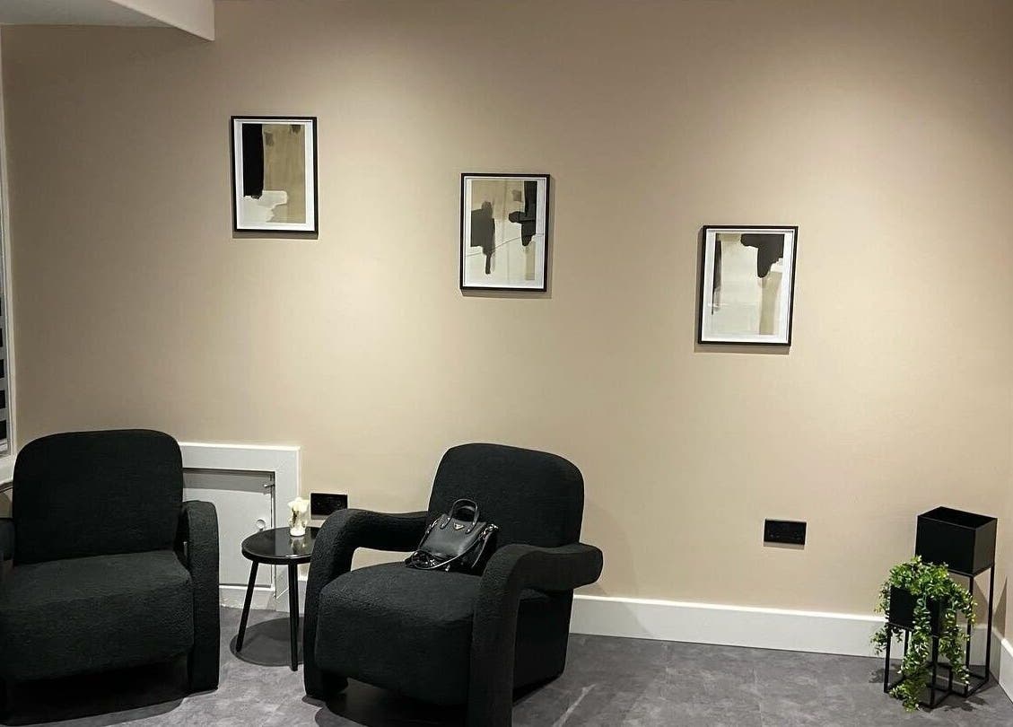 Elegant seating area at Beyond Beauty by Louise, Ayr, Scotland with dark chairs and minimalist decor.
