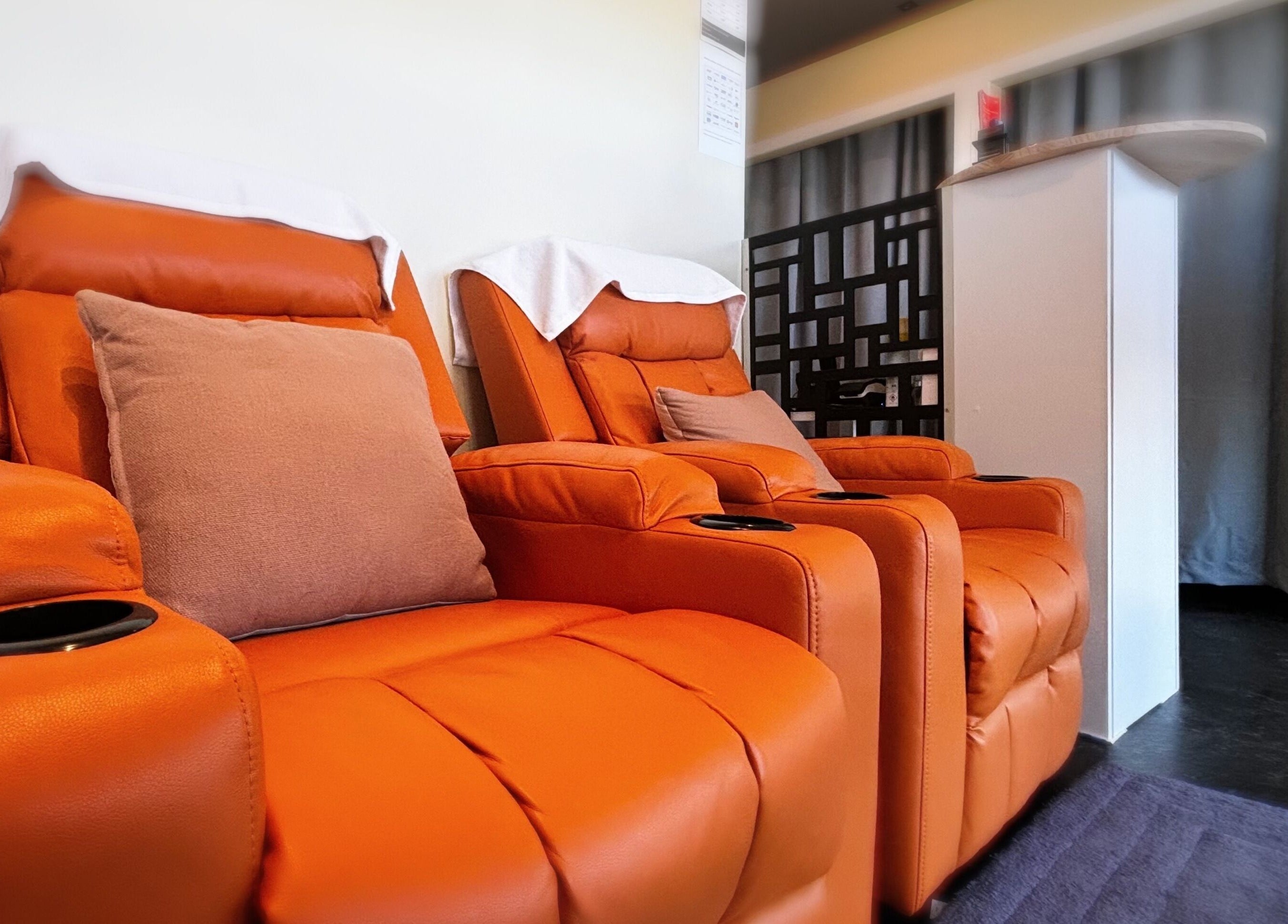 Relax in plush, orange recliners at Swan Massage, Osborne Park, Western Australia, AU for a soothing experience.