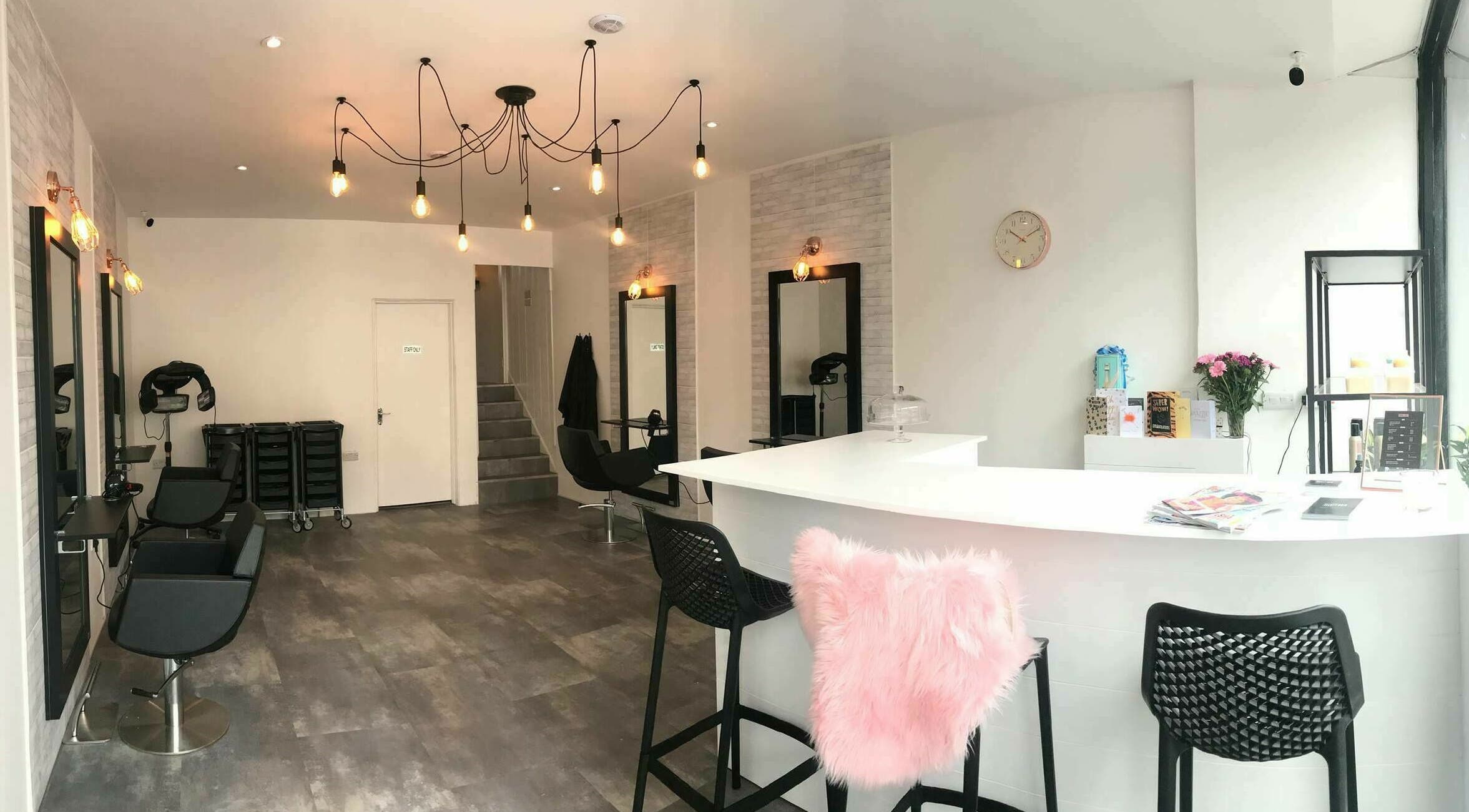 Modern interior of Illicit Hair salon in Eastbourne, England featuring stylish seating and bright decor.