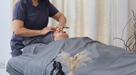Therapist massaging a client's face at Spaholics Home Wellness, Dubai, Dubai, AE.