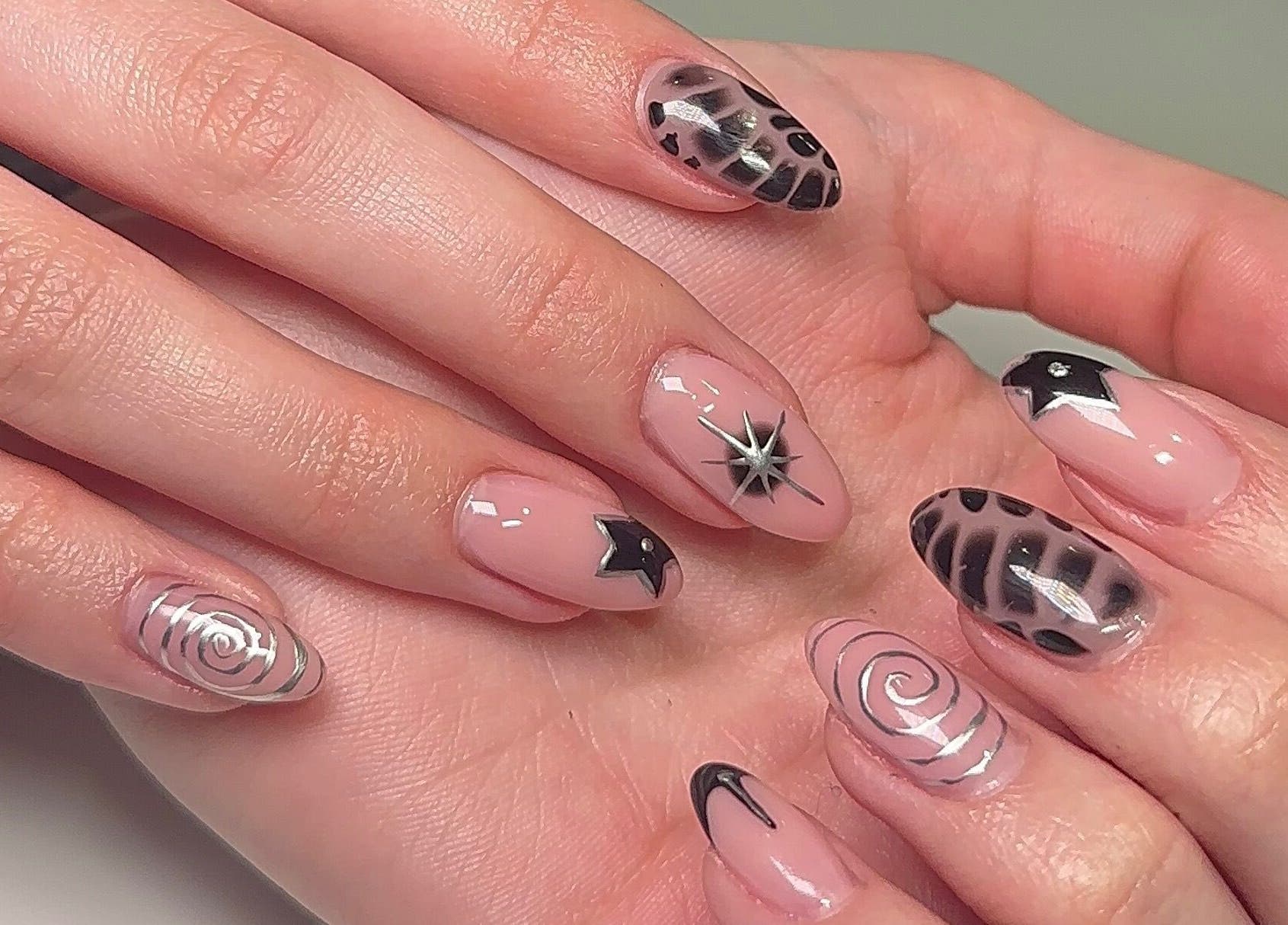 Stylish nail art at Beauty by H.E.R in Moulton, England, GB, featuring black and silver designs.