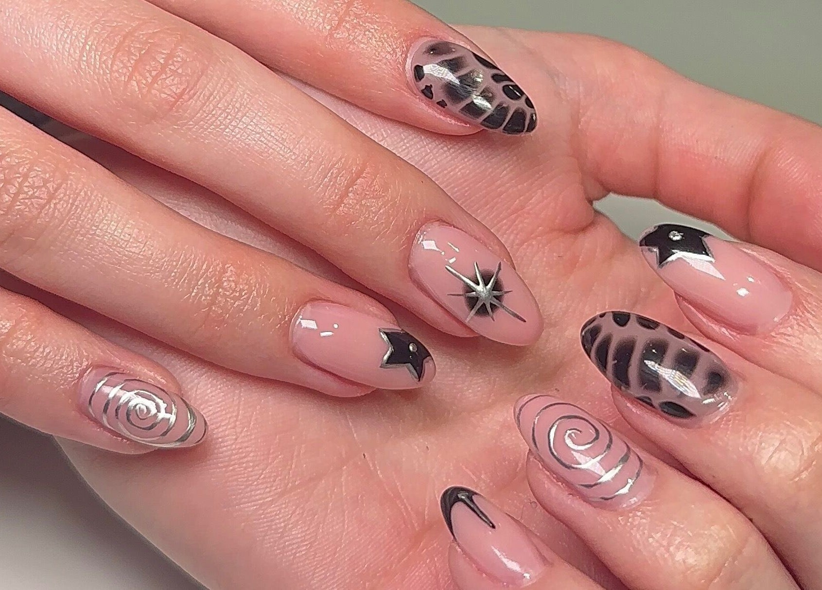 Stylish nail art at Beauty by H.E.R in Moulton, England, GB, featuring black and silver designs.