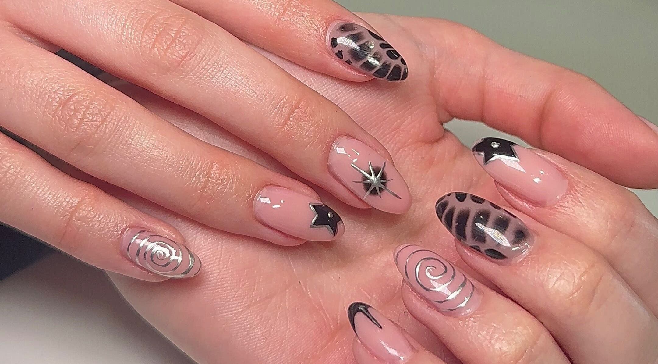 Stylish nail art at Beauty by H.E.R in Moulton, England, GB, featuring black and silver designs.