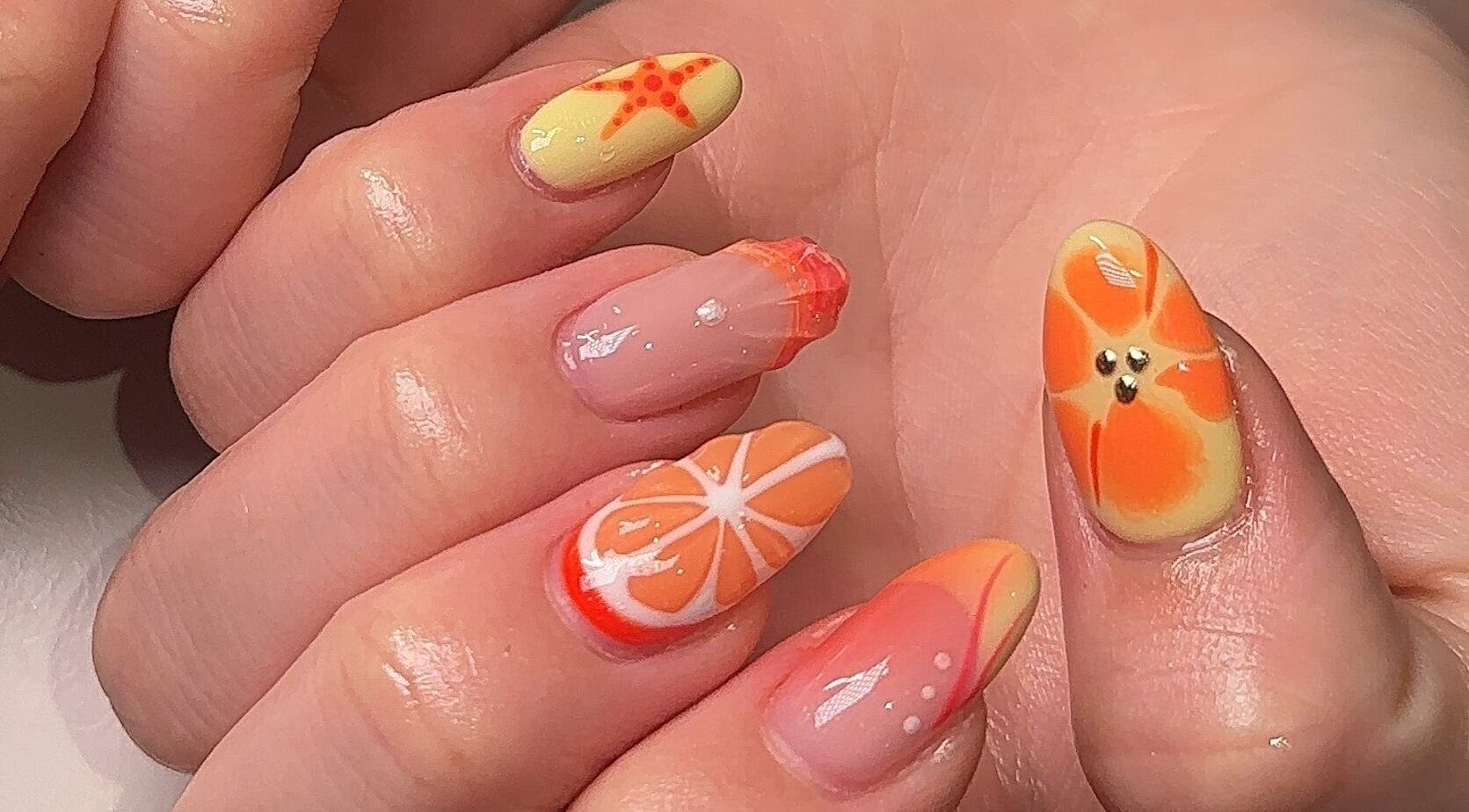 Vibrant orange tropical nail art by Beauty by H.E.R in Moulton, England, GB.