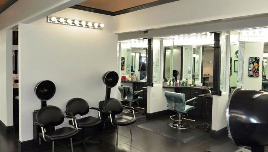 Modern salon interior at Hair By Jessie G, Hedgesville, West Virginia, US, featuring styling stations and dryers.