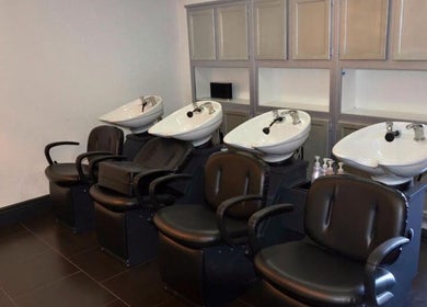 Chic wash stations at Hair By Jessie G in Hedgesville, West Virginia, US, featuring sleek black chairs.