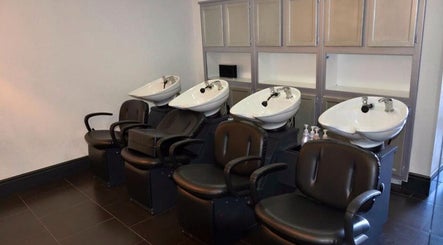 Chic wash stations at Hair By Jessie G in Hedgesville, West Virginia, US, featuring sleek black chairs.