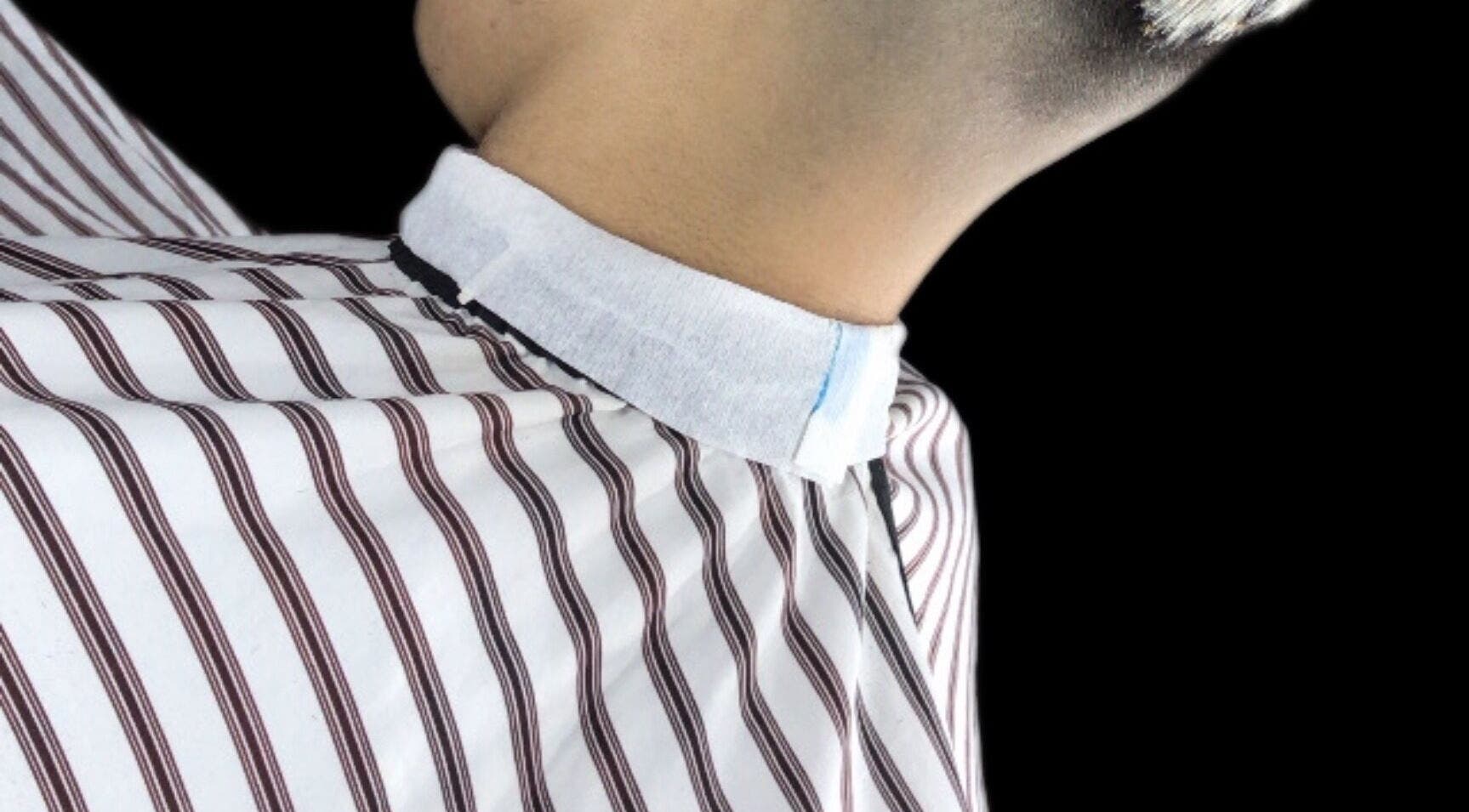 Cuello recién recortado en Barbero nahuel, Rosario, Santa Fe, AR, con capa de rayas blancas y negras.