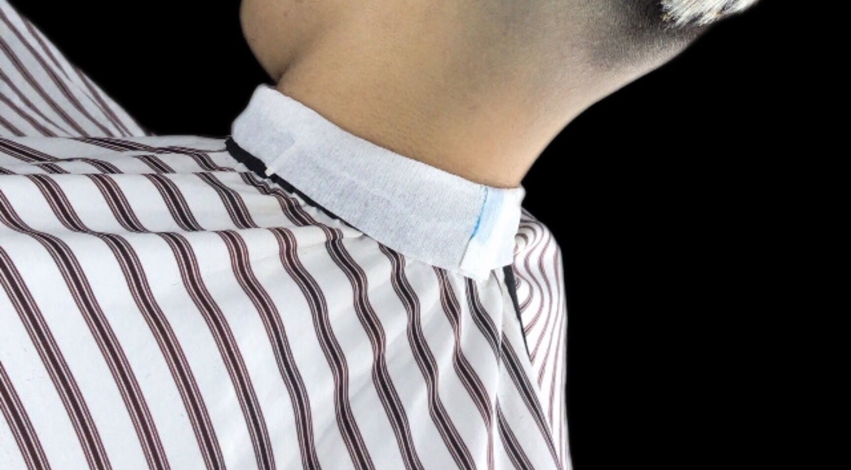 Cuello recién recortado en Barbero nahuel, Rosario, Santa Fe, AR, con capa de rayas blancas y negras.