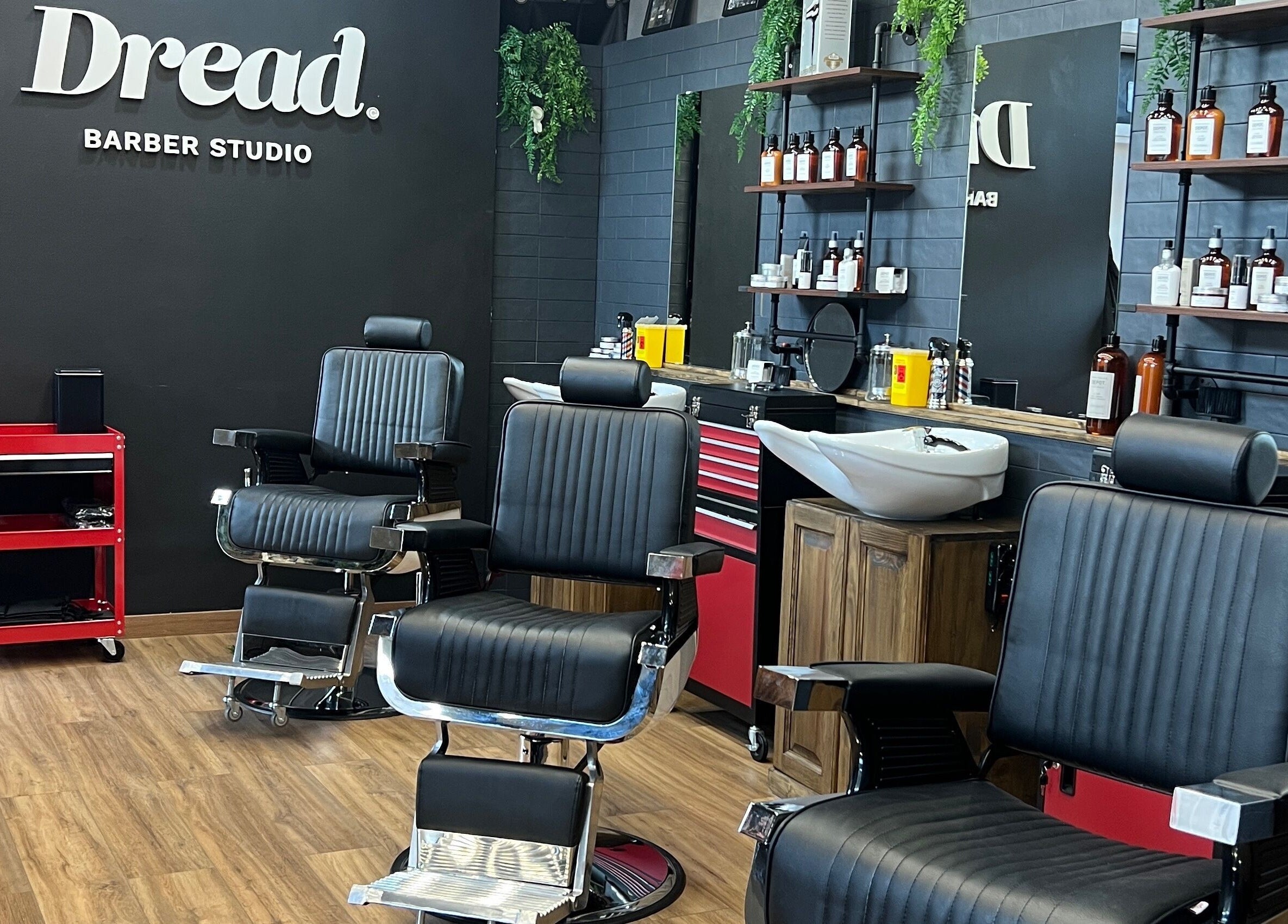 Interno elegante di Dread Barber Studio, Livorno, Toscana, IT, con poltrone e attrezzature da barberia moderne.