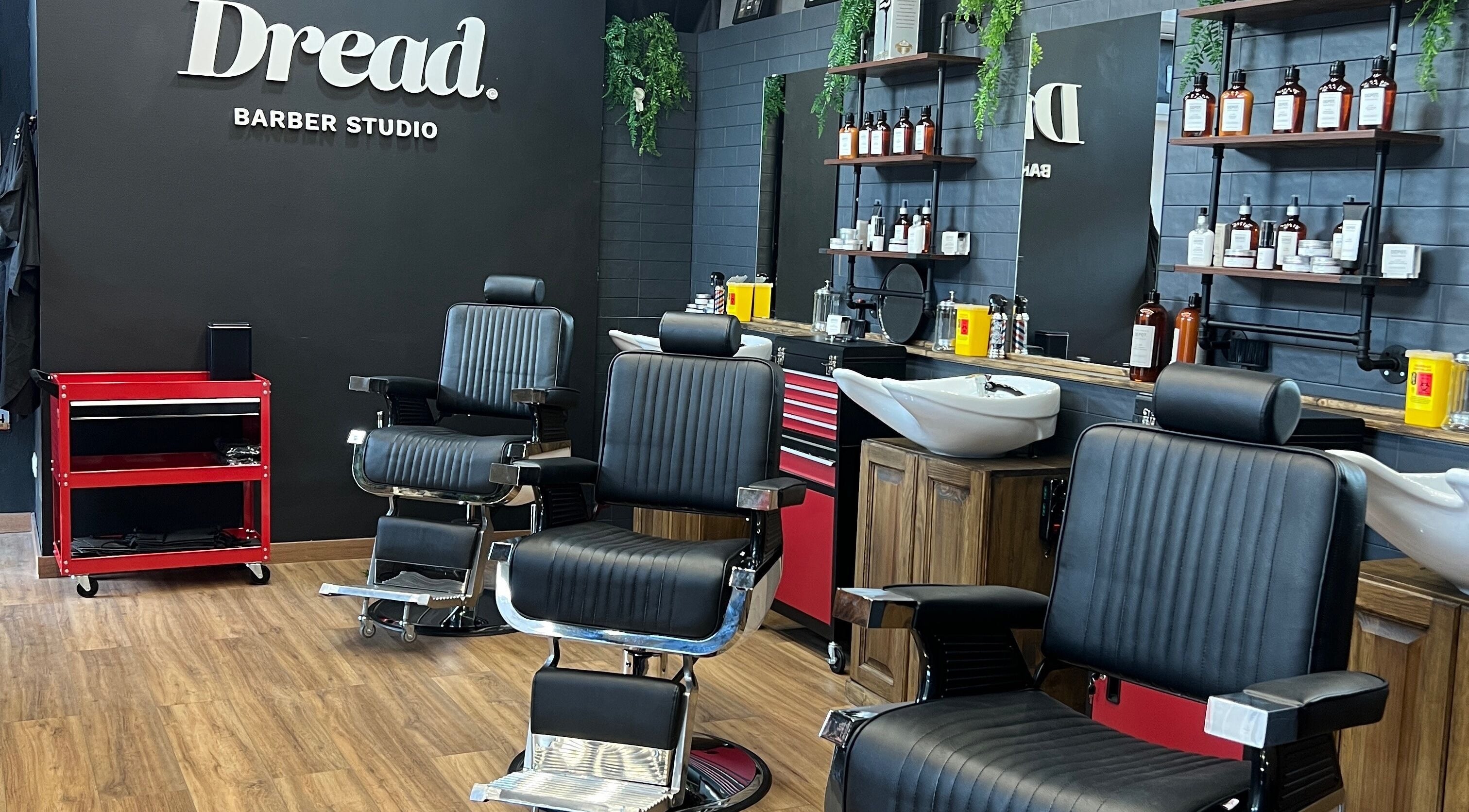 Interno elegante di Dread Barber Studio, Livorno, Toscana, IT, con poltrone e attrezzature da barberia moderne.